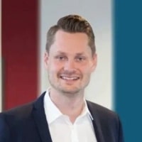 Jan Lutz, Director HR | co-founder, Sustainability Jobs List seen in white color shirt and black color suit
